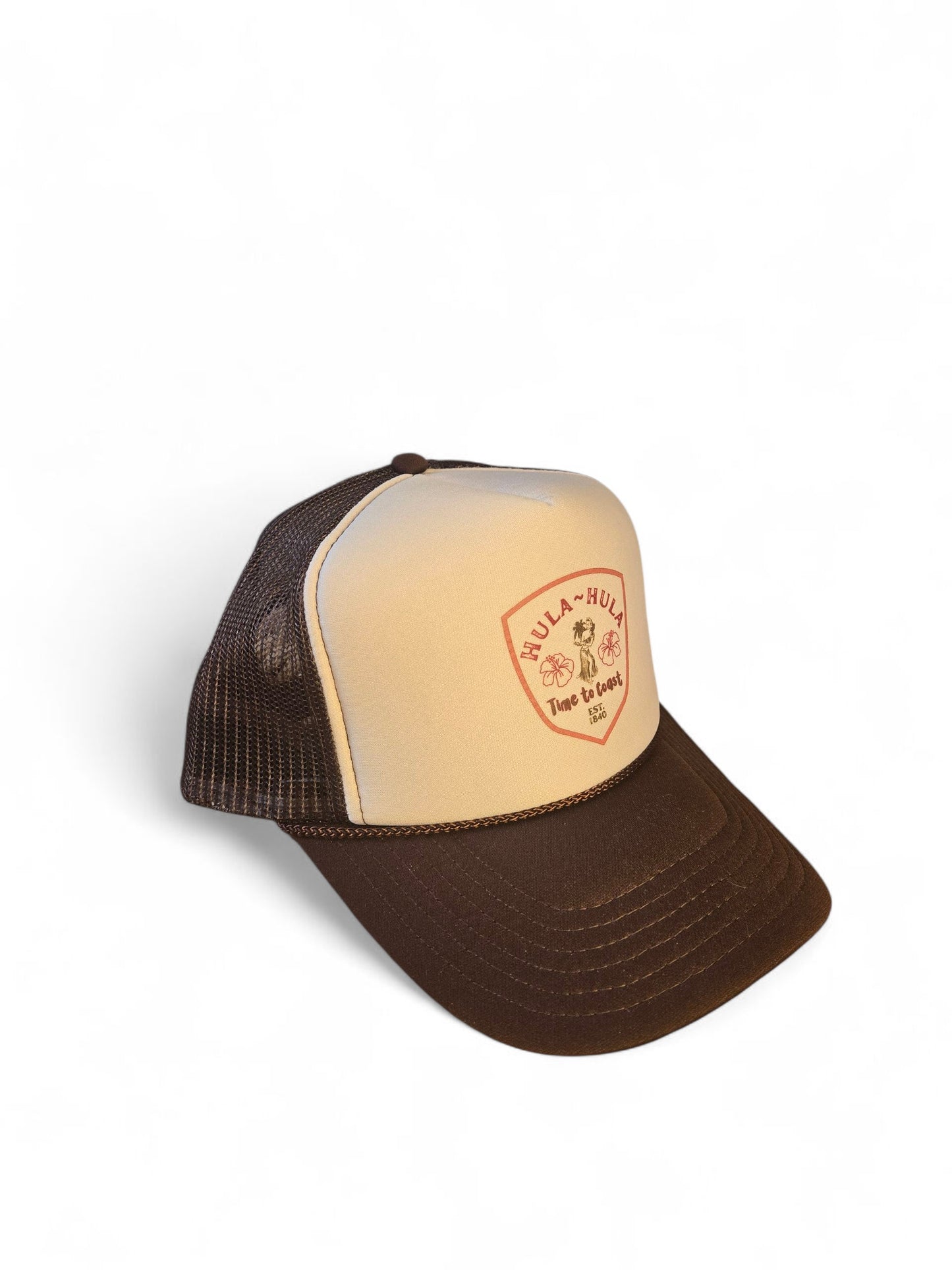 Side view laydown of a foam high profile trucker hat. Graphic is printed with Time to Coast Hula Hula girl. Hat color is beige and brown with a brown mesh back.