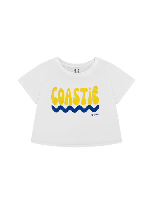 Laydown of a white Time to Coast Palm Cloth Coastie crop Tee. Coastie graphic is yellow with a blue wave. 