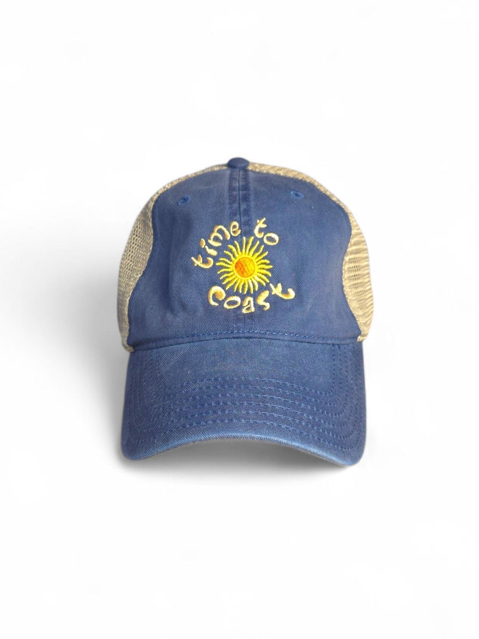 Laydown of  Time to sun low profile trucker twill hat with tan mesh back and navy washed twill. Graphic is sun with time to coast circling the sun. Embroidery is yellow.