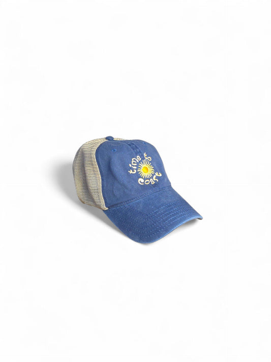 Side laydown of the Time to sun low profile trucker twill hat with tan mesh back in washed navy. Graphic is sun with time to coast circling the sun. Embroidery is yellow.