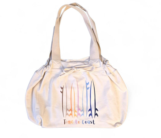 Laydown of the Florida Fleece Hobo Beach Bag, with drawstring closure. Creme colored with Time to Coast Board Meeting Graphic with multi colored surf and sup boards. 