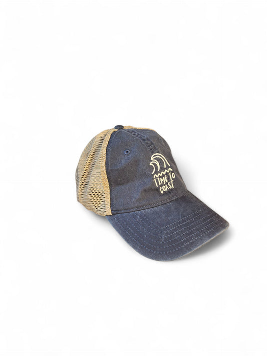 Laydown of the Time to swell low profile trucker washed navy twill hat with tan mesh back. Graphic is an embroidery of surf swell and waves with time to coast in white.