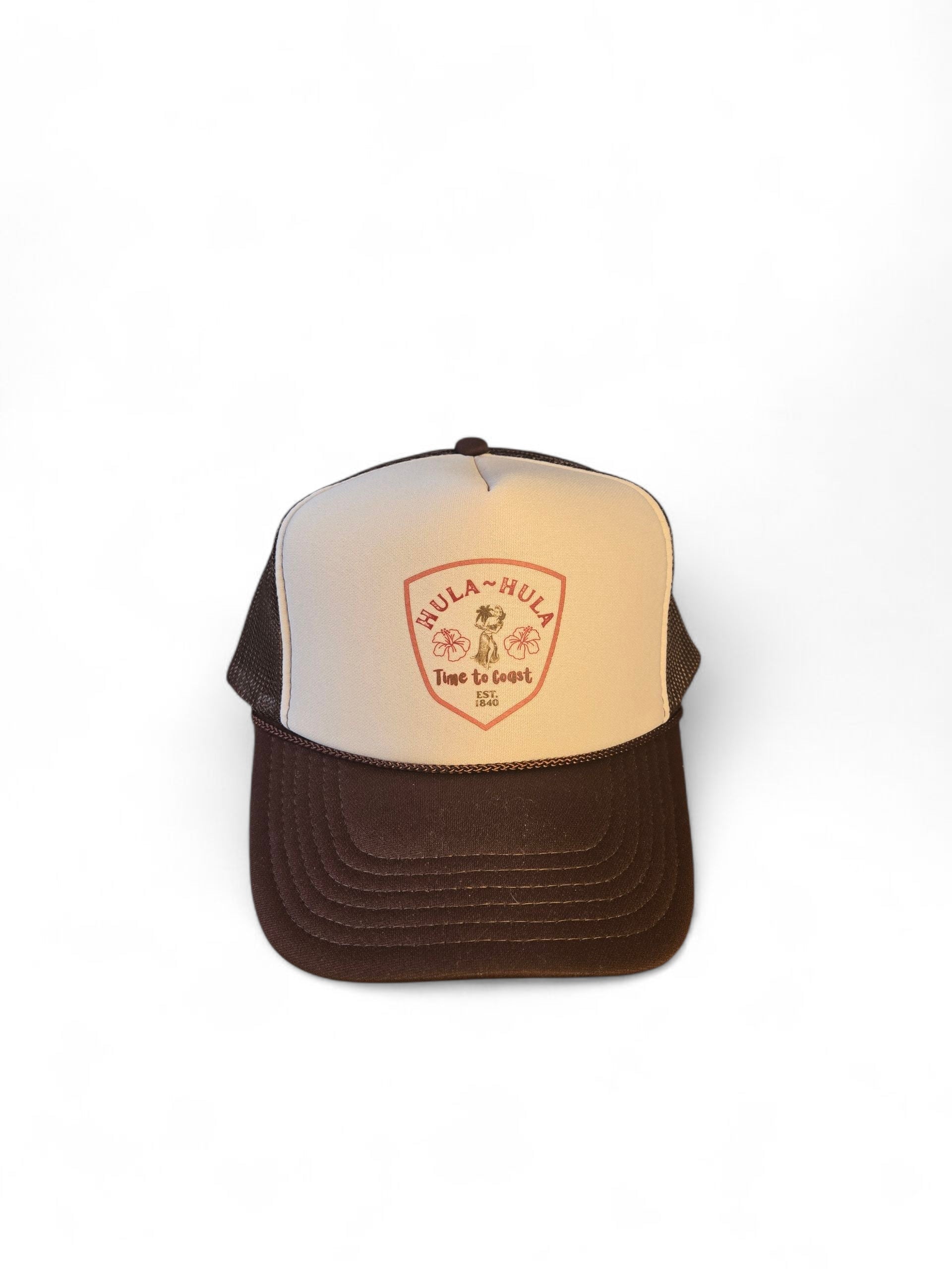 Laydown of a foam high profile trucker hat.  Graphic is printed with Time to Coast Hula Hula girl. Hat color is beige and brown with a brown mesh back.