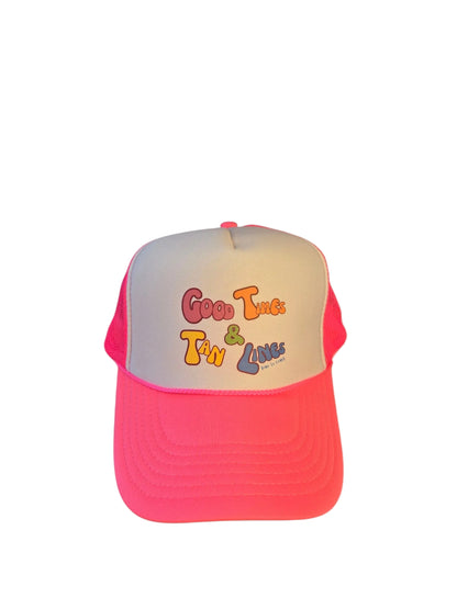 Laydown of a foam high profile trucker hat.  Graphic is printed with Time to Coast Good Times and Tan Lines slogan. Hat color is bright pink bill and mesh back with white front. 