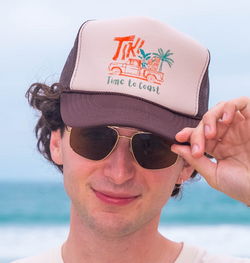 Person wearing a cap and sunglasses on a beach with ocean view