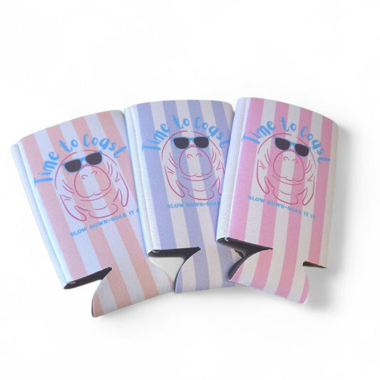 laydown of all three colors of the  neoprene slim coozie with a graphic of a manatee wearing sunglasses. Coral, lilac and pink
